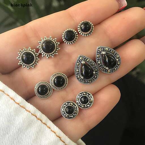 a pair of earrings with a black and white stone.