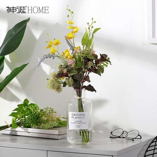 a vase filled with flowers and greenery.