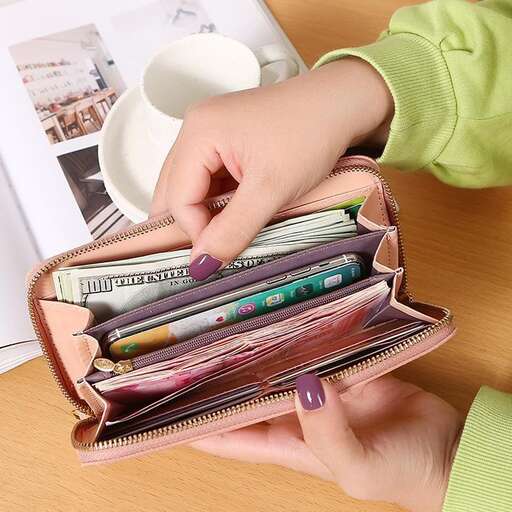 a woman holding a coffee cup in her purse.