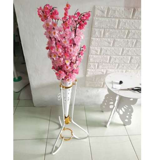 a vase of pink flowers sitting on a white table.