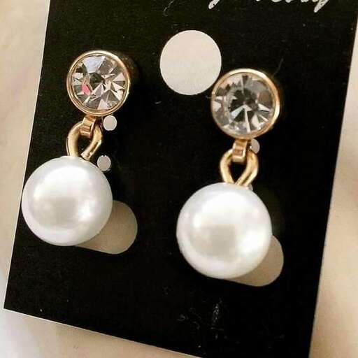a pair of earrings with a pearl and diamond.