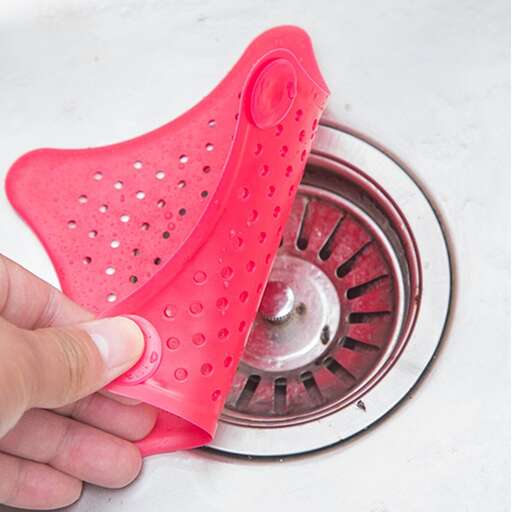 a hand holding a red plastic umbrella in a sink