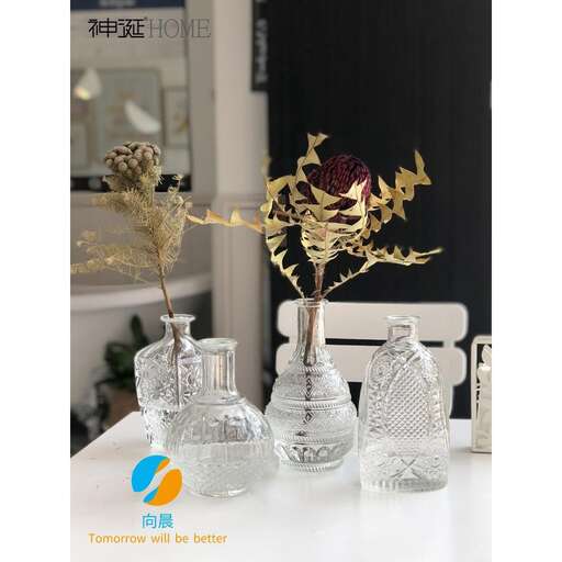a table with three vases on it and a flower in it.