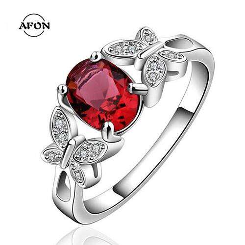 a ring with a red sapphire and diamonds
