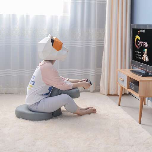 a woman sitting on a stool in front of a television.