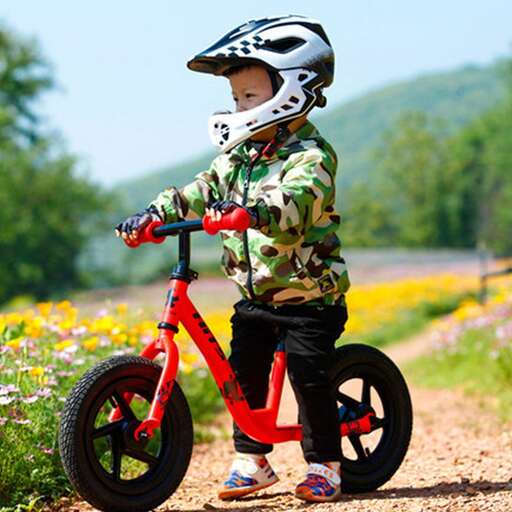 a young boy rides his bike with his helmet on.