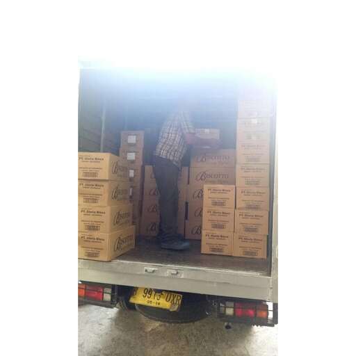 a man standing in the back of a truck full of boxes.