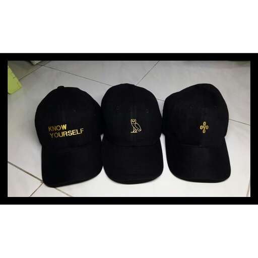 a black baseball cap with gold logo