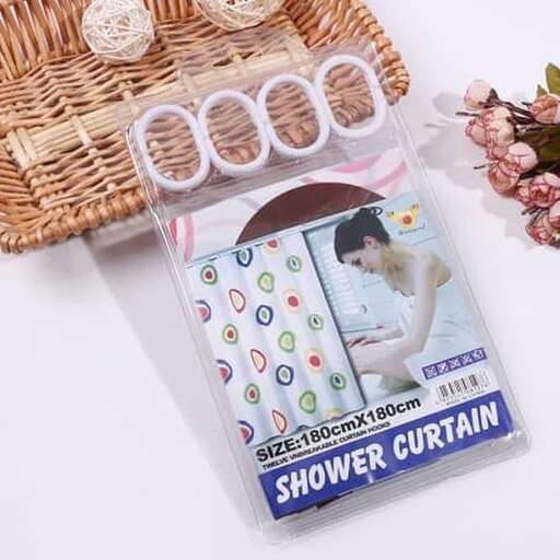 a wicker basket with a shower curtain and flowers.