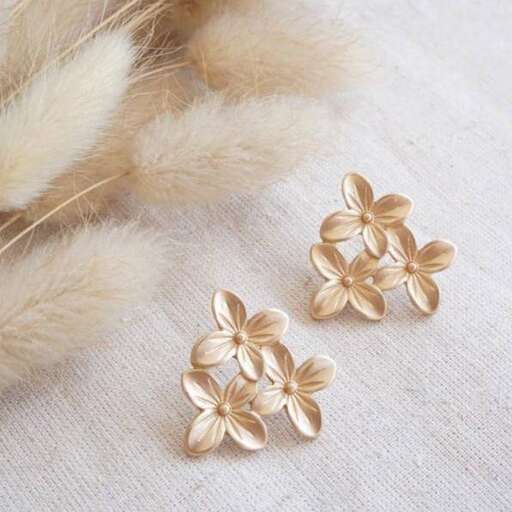 this is a pair of gold flower stud earrings.