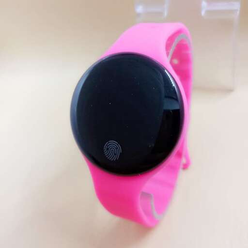 a pink watch with a black face and a black plastic lid.
