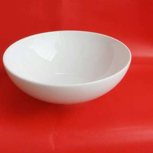 a white bowl on a red table
