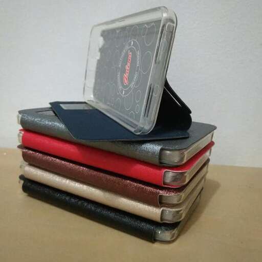 a stack of books with a cell phone on top of it.