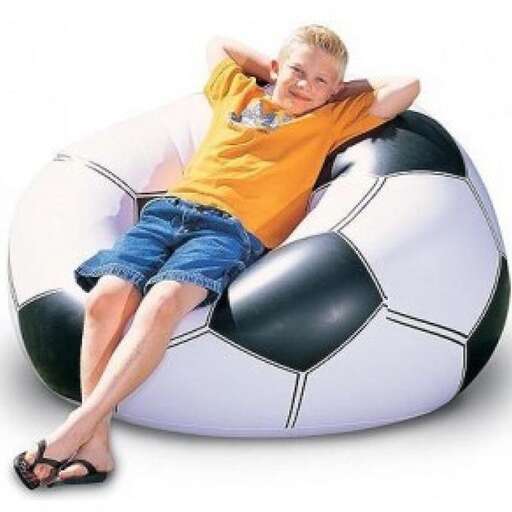a boy is sitting on a soccer ball.