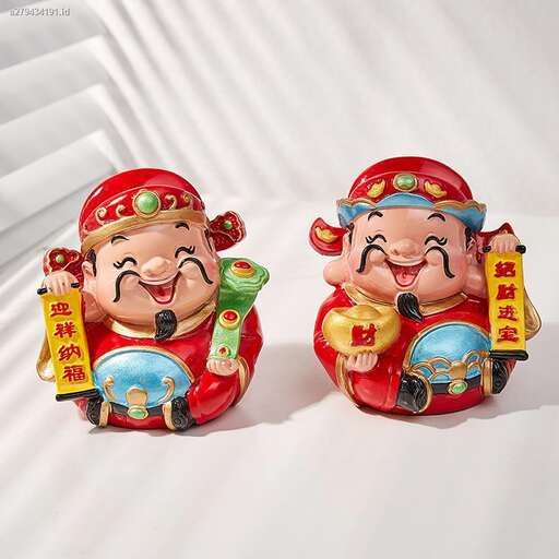 two small figurines of two people sitting on a white surface.