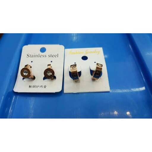 a pair of earrings on a plastic tray.