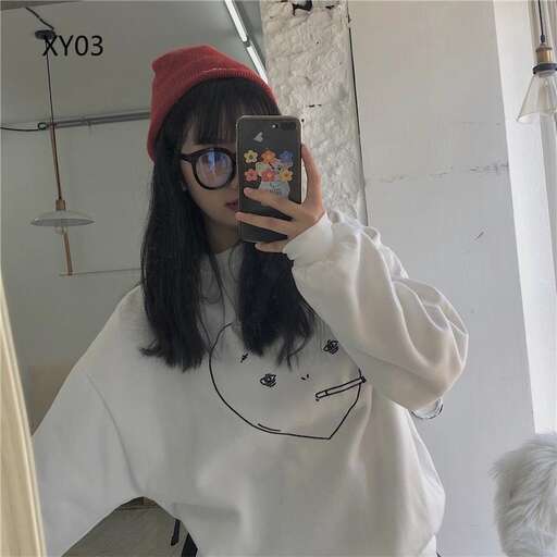 a girl with black glasses and a red beanie is taking a selfie.