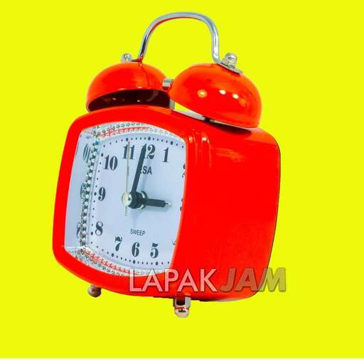 a red alarm clock with a white face and red dials.