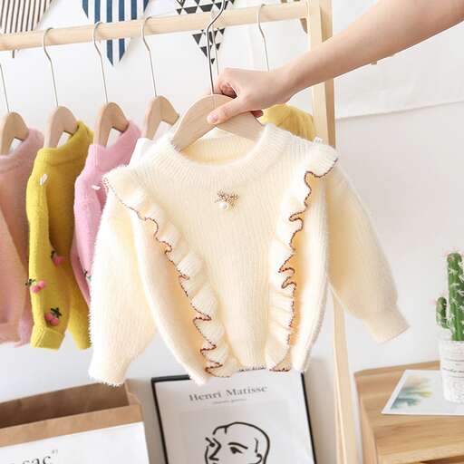 a baby's sweater hanging on a hanger