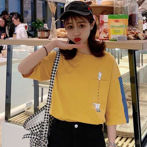 a woman in a yellow shirt and black pants.