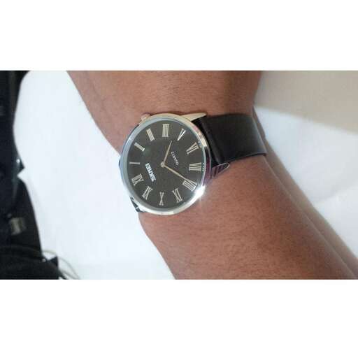 the watch is made with a black leather strap.