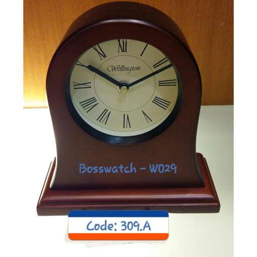 a clock that is on a table with a sign.