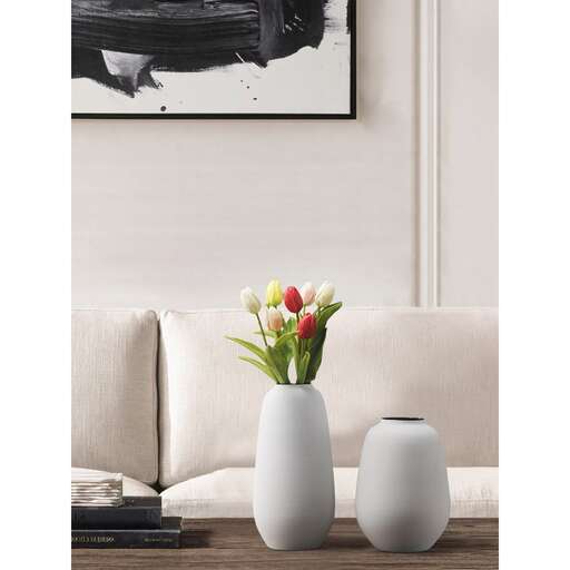 a vase with flowers in it sitting on a coffee table.