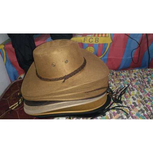 a brown hat sitting on top of a suitcase.