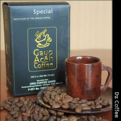 a coffee cup and a pile of coffee beans.