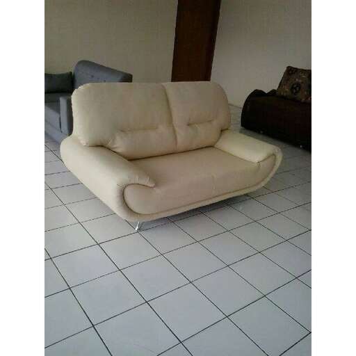 a white couch with a cushion on it.