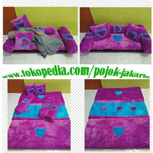 a bed with a purple pillow and a blue and pink heart