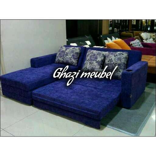 a blue couch with a white pillow and a blue pillow.