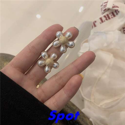 a wedding ring with three small pearls on the finger.