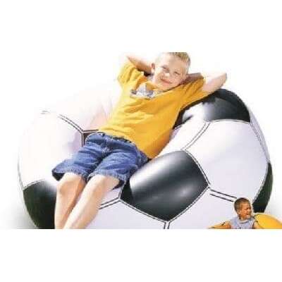 a boy sitting on top of a large soccer ball.