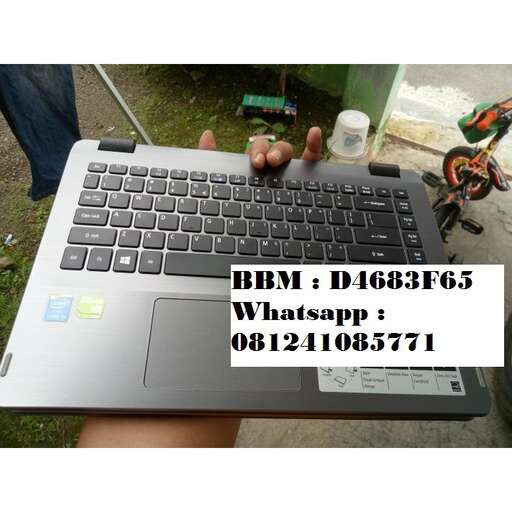 a person holding a laptop computer with a cell phone on it.