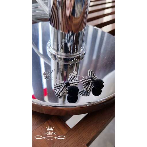 a silver candle holder with black flowers on it.