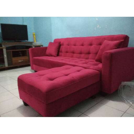 a red couch in a room with a tv and a tv.