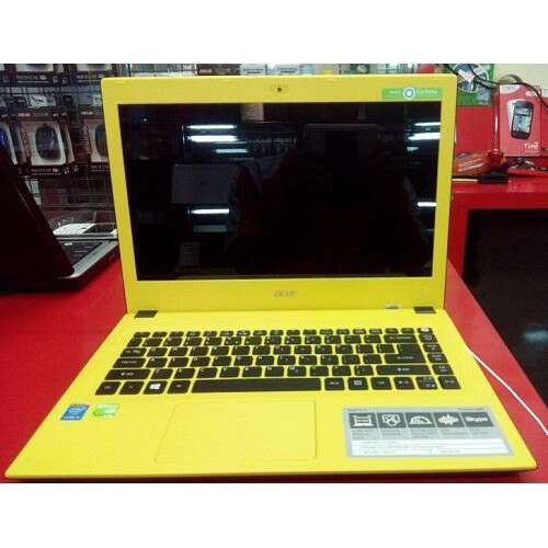 a yellow laptop on a red table in a store.