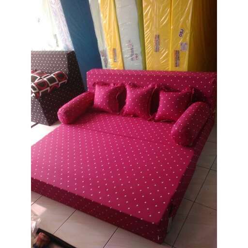 a couch with a pink cushion and pillows on it.