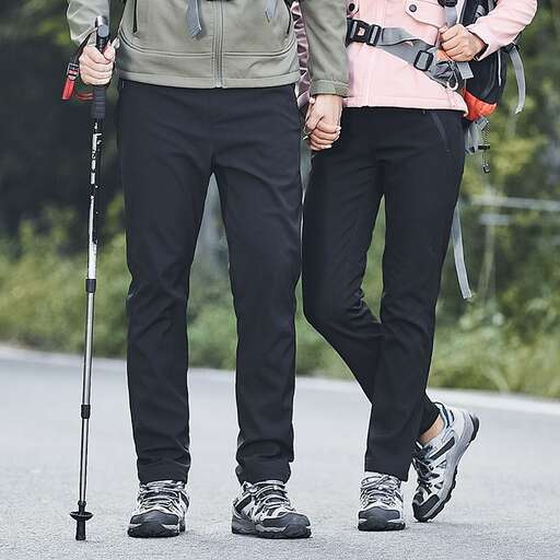 a couple walking down a road holding hands.