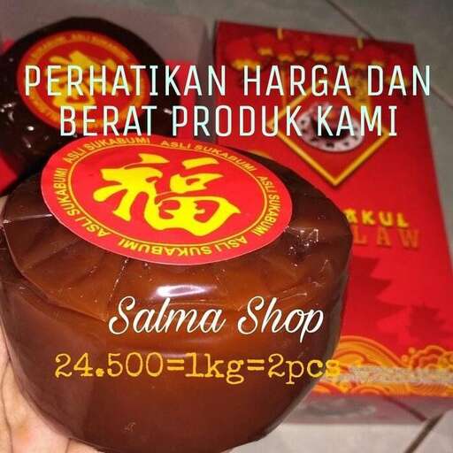 a person holding a chocolate covered pastry in front of a store.