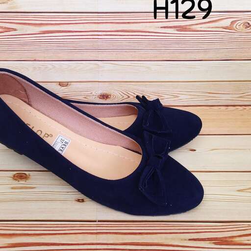 a pair of black shoes with a bow on the side.