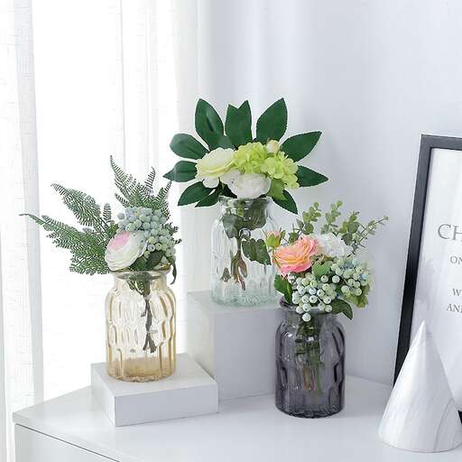 a white table topped with vases of flowers.