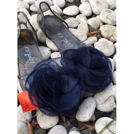 a pair of sandals sitting on rocks next to a pile of rocks.