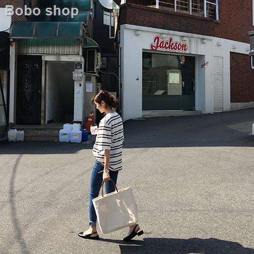a woman walking in the street with a shopping bag