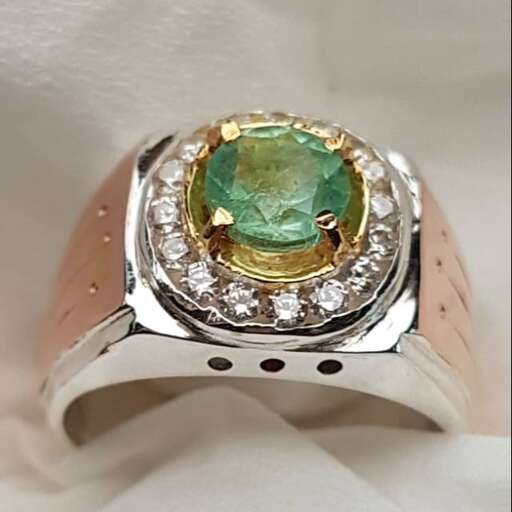 a ring with a green stone and diamonds.