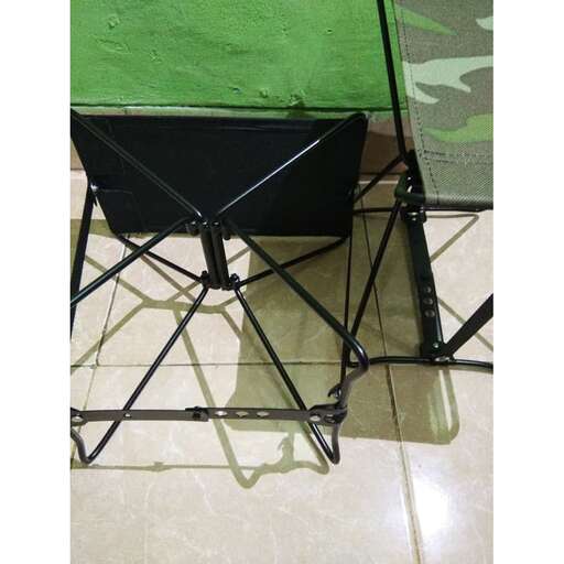 a chair with a black seat and a green wall.